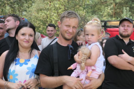 Kobieta, mężczyzna i dziecko. Mężczyzna trzyma dziecko na ręku 