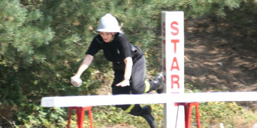 Zawody pożarnicze. Strażak pokonuje tor przeszkód 