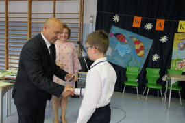 Chłopiec odbiera gratulacje od mężczyzny - wójta Gminy Radomsko