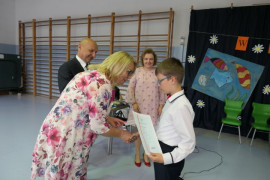 Chłopiec odbiera gratulacje od kobiety - kierownik GZEASZ