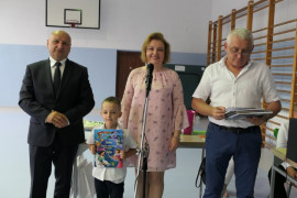 Kobieta, dwaj mężczyźni i wyróżniony przez nich chłopiec