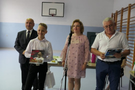 Kobieta, dwaj mężczyźni i wyróżniony przez nich chłopiec