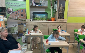 Klasa, ławki. Dzieci podczas  rozwiązywania zadań 