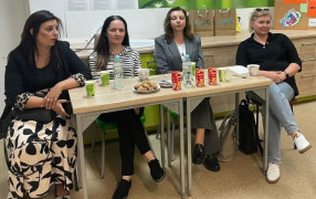 Cztery kobiety siedzą obok siebie 
