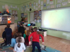 Grupa dzieci podczas oglądania prezentacji przygotowanej przez strażaków 