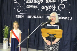 Kobieta stoi przy mikrofonie i przemawia 