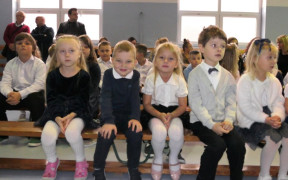 Dzieci siedzą obok siebie na ławce 