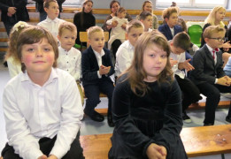 Dzieci siedzą obok siebie na ławce 