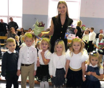 Dzieci i kobieta stoją obok siebie 