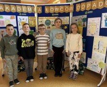 Uczniowie przez ścianką, na której znajdują się prace plastyczne 