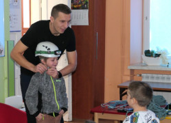 Mężczyzna przymierza chłopcu kask 