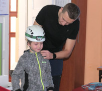Mężczyzna przymierza chłopcu kask 
