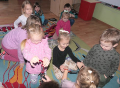 Grupa dzieci siedząca obok siebie 