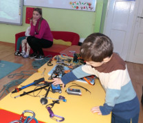 Chłopiec ogląda sprzęt przeznaczony do wspinaczki górskiej 