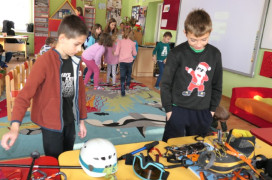 Dwaj chłopcy oglądają sprzęt przeznaczony do wspinaczki górskiej 