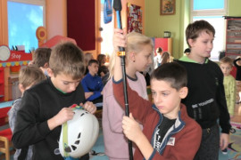 Dzieci przymierzają sprzęt wykorzystywany we wspinaczce górskiej 