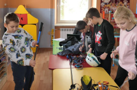 Dzieci oglądają sprzęt przeznaczony do wspinaczki górskiej 