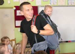 Mężczyzna i dzieci. Mężczyzna niesie w plecaku dziewczynkę 