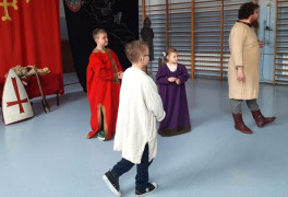 Mężczyzna i trójka dzieci stoją obok siebie. Wszyscy ubrani są w historyczne stroje 