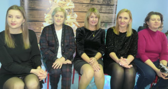 Pięć kobiet siedzi obok siebie na krzesłach 