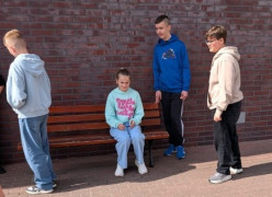 Czworo uczniów znajduje się przed szkołą 
