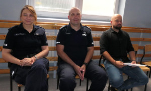 Kobieta i dwaj mężczyźni siedzą na krzesłach 