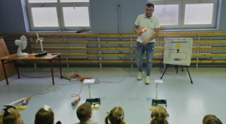Mężczyzna tłumaczy dzieciom skąd bierze się prąd 