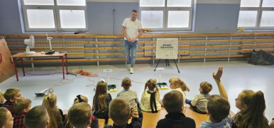 Mężczyzna tłumaczy dzieciom zasady powstawania prądu 