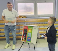 Mężczyzna i chłopiec stoją przy kolorowej planszy 
