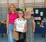 Dziewczynka w towarzystwie dwóch kobiet tuż po odebraniu dyplomu