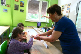Pracownicy naukowi pokazują uczniom różne rodzaje materiałów włókienniczych 