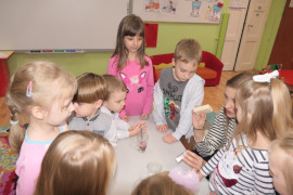 Dzieci i nauczycielka. Pani pokazuje i omawia środki czystości 