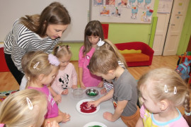 Dzieci maczają paluszki w kolorowym brokacie 