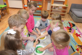 Dzieci dotykają palcami kolorowego brokatu