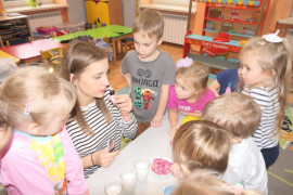 Dzieci stoją obok nauczycielki. 