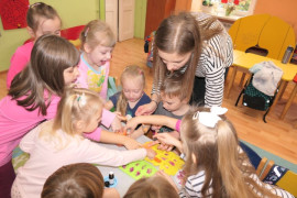 Dzieci pod kierunkiem nauczyciela robią różnokolorowe mydełka 
