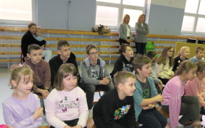Grupa dzieci siedząca obok siebie na ławce 
