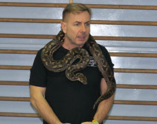 Mężczyzna, na szyi którego znajduje się wąż