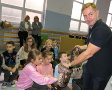 Dzieci dotykają węża. Węża trzyma mężczyzna