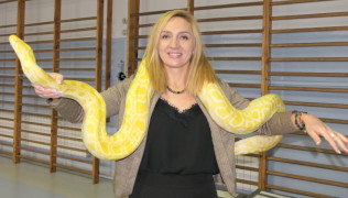 Kobieta trzyma na barkach węża 