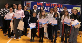 Grupa osób na wspólnym zdjęciu. Dzieci trzymają w ręku dyplomy 