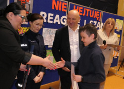 Chłopiec z rąk kobiet i mężczyzny odbiera nagrody