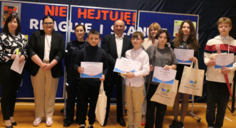 Grupa osób na wspólnym zdjęciu. Nagrodzone w konkursie osoby trzymają w dłoniach dyplomy