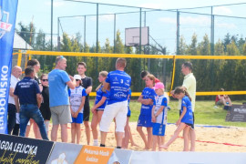 Grupa osób na boisku do gry w plażową piłkę siatkową 