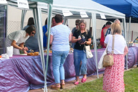 Stoiska wystawiennicze i grupa osób przy nich 