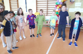 Dzieci stoją obok siebie i trzymają się za ręce 