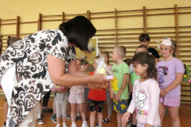 Kobieta wręcza nagrody dzieciom 