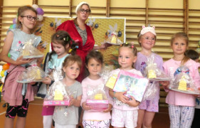 Dzieci stoją obok siebie. W ręku trzymają nagrody 