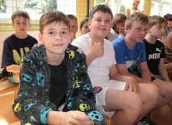 Grupa dzieci siedzi obok siebie 