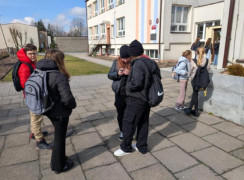 Dzieci stoją przed szkołą 